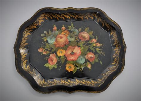 A Black And Gold Tray With Flowers Painted On It