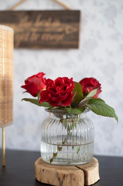 Un Jarr N De Rosas Rojas Se Sienta En Una Mesa Con Un Cartel Que Dice