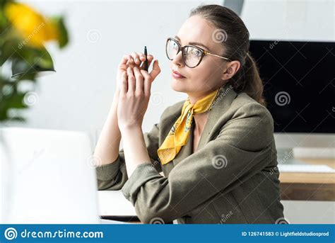 Beautiful Pensive Businesswoman Sitting At Workplace And Looking Away