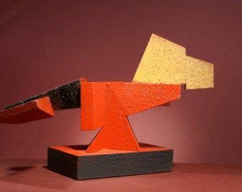 An Orange And Black Sculpture Sitting On Top Of A Wooden Table Next To