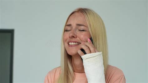 Close Up Face Of Cheerful Blonde Young Woman With Broken Arm Wrapped In