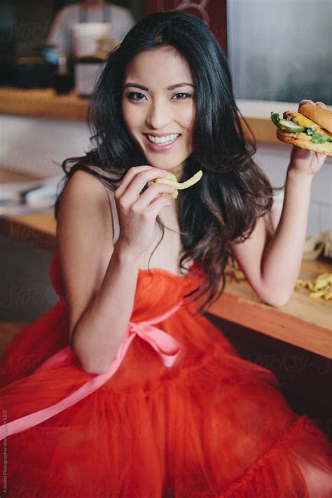 Girl Eating A Burger In A Red Dress By Stocksy Contributor A Model Photographer Stocksy