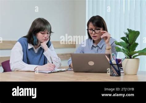 College Student Girl Sitting With Female Teacher Studying Individually In Class Woman Mature