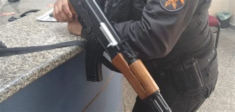 Policiais militares apreendem uma réplica de fuzil AK 47 depois de