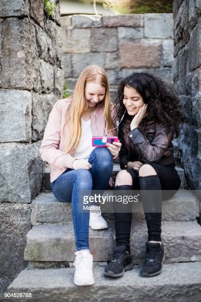 Two Preteen Girls Sharing Earphones Photos And Premium High Res