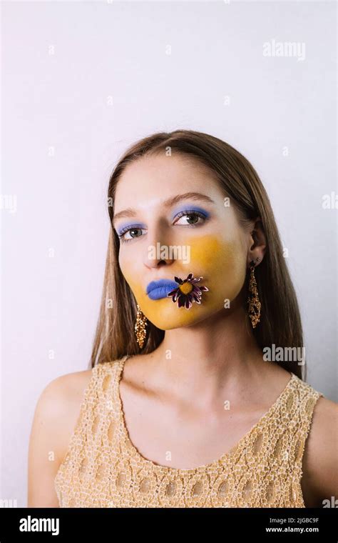 Portrait Of Pretty Blonde Girl With Extreme Blue Yellow Make Up She