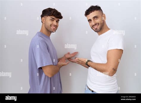 Homosexual Gay Couple Standing Over White Background Inviting To Enter Smiling Natural With Open