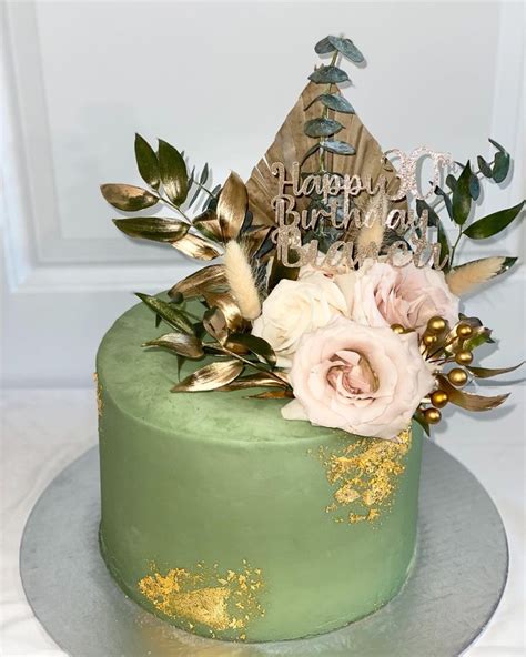 There Is A Green Cake With Flowers On The Top And Happy Birthday