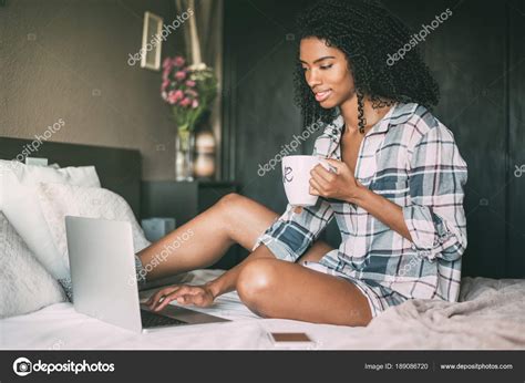 Jeune Femme Avec Ordinateur Portable Assise Sur Le Lit Dans La Chambre