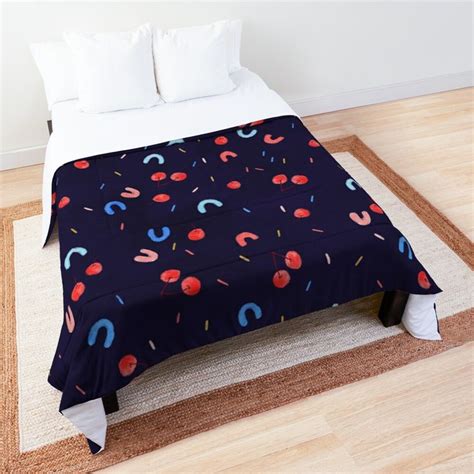 A Bed Covered In A Blue Blanket With Sprinkles And Circles On It