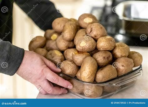 Patatas Sin Pelar Horneadas En Una Hoja De Hornear Foto De Archivo