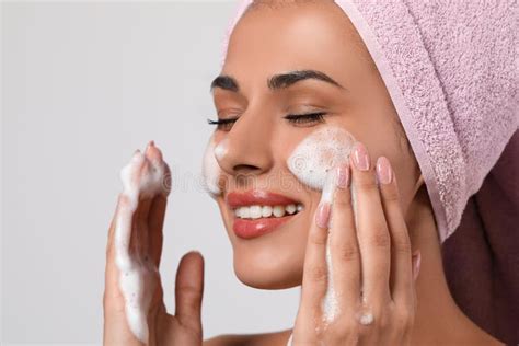 Beautiful Woman Applying Facial Cleansing Foam On Background Stock