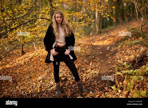 A Slim Blonde Woman Girl Standing Alone In Woodland Autumn Afternoon