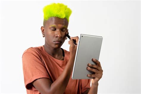 Premium Photo A Gay Black Man Putting On Makeup Lgtbi Concept Correcting Blemishes With A Mirror