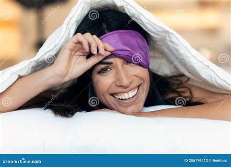 Pretty Young Woman Pulling Up Sleeping Mask While Looking At Camera