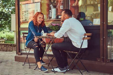 A Couple Dating Drinking Coffee Sitting Near The Coffee Shop Outdoors