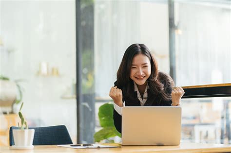 흥분 아시아 여자 앉아 책상 느낌 기쁘게 승리 온라인 복권 행복 한 흑인 여자 기뻐 하 게 직장에서 승진 되 고 노트북에서