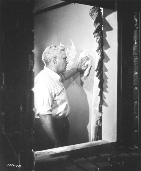 An Old Black And White Photo Of A Man In Front Of A Mirror Holding