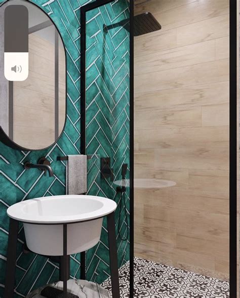 A Bathroom With Green Tiled Walls And A Round Mirror On The Wall Above