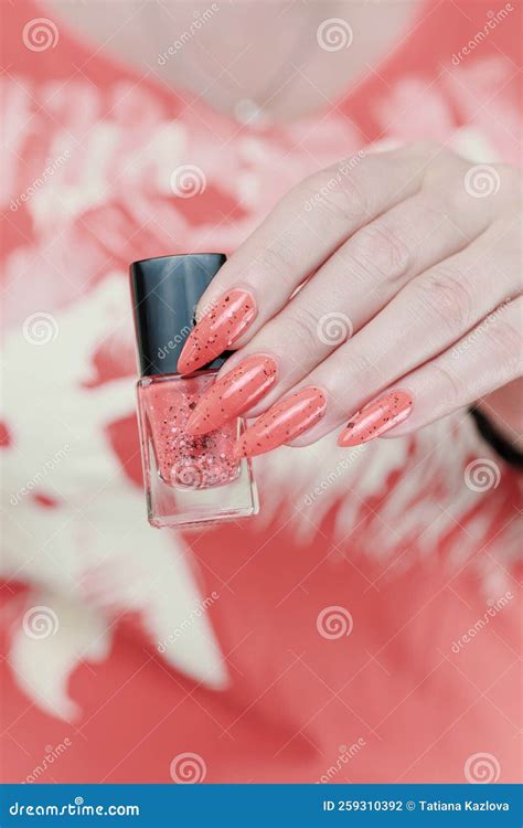 Female Hands With Long Nails And Neon Pink Coral Manicure Stock Photo