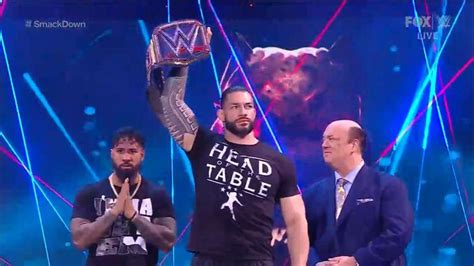 Two Men Standing Next To Each Other While Holding Up A Wrestling Trophy