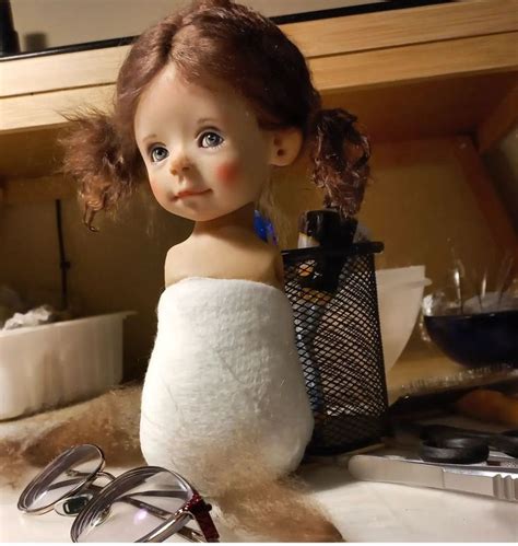 A Doll Sitting On Top Of A Counter Next To Glasses