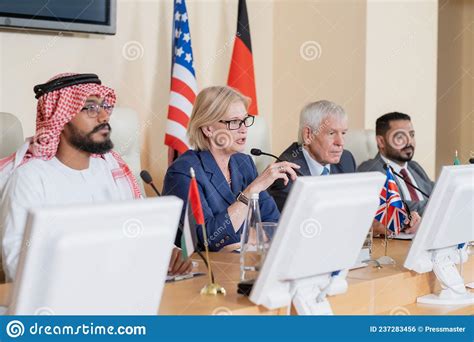 Blond Mature Female Delegate Making Speech For Audience Stock Photo