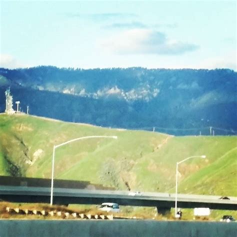 A Highway With Mountains In The Background And Cars Driving On The Road