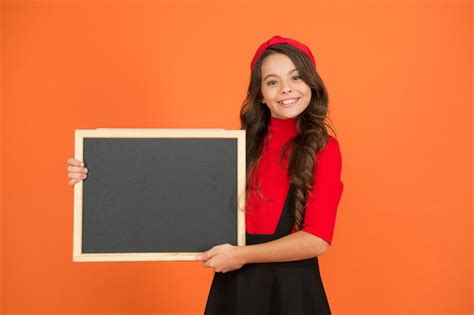 Pour Votre Attention Une Fille Heureuse Tient Un Tableau Noir Sur Fond