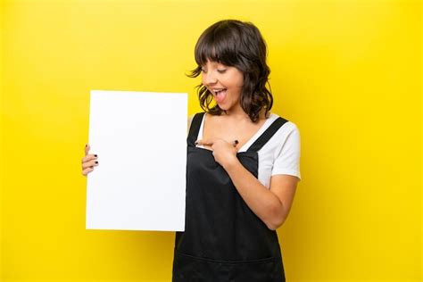Camarera de restaurante mujer latina aislada en un fondo amarillo sosteniendo un cartel vacío