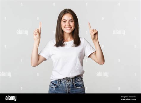 Attractive Smiling Brunette Girl Pointing Fingers Up Showing Logo Stock Photo Alamy