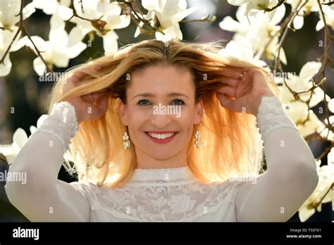 Femme blonde conduisant ses mains dans ses cheveux Banque de photographies et dimages à haute