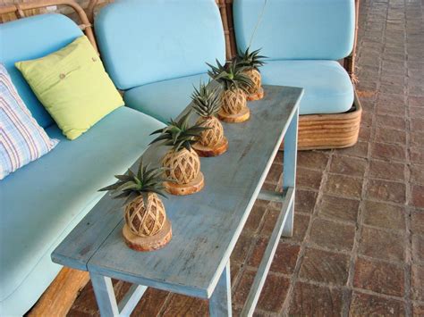 Three Pineapples Sitting On Top Of A Wooden Table Next To Blue Couches