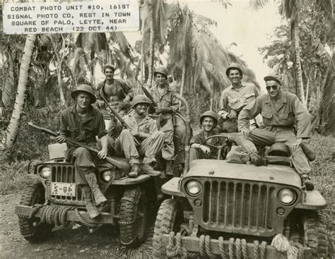 Members Of Combat Photo Unit 10 Sit Atop Two Jeeps On A Jungle Road At