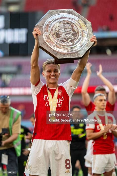 Martin Odegaard Of Arsenal Celebrates By Lifting The Trophy After