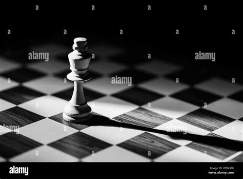 White Single King Chess Piece With Shadow Against A Black Background