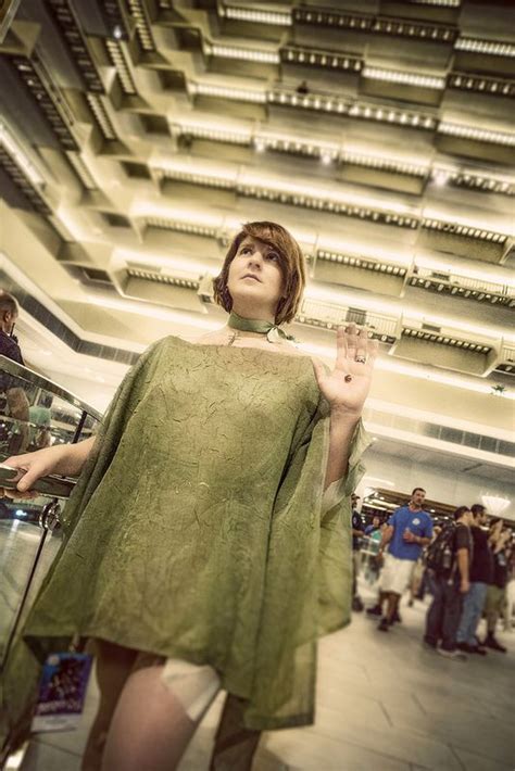 A Woman In A Green Dress Is Holding Her Hand Up