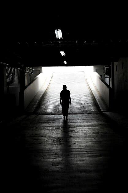 Premium Photo Rear View Of Silhouette Man Walking In Illuminated Tunnel