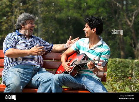 El Padre escucha a su hijo tocar la guitarra Fotografía de stock Alamy