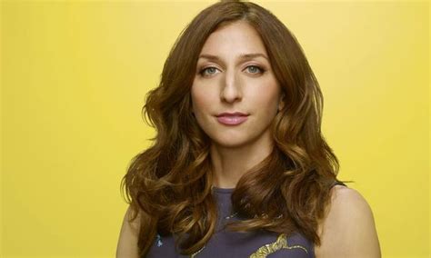 A Woman With Long Brown Hair And Blue Eyes Posing For A Photo In Front