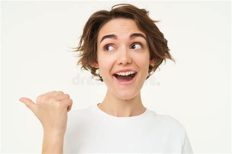 Image Of Excited Brunette Woman With Short Haircut Pointing Left Smiling And Looking Happy