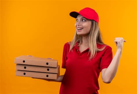 Olhando Para O Lado Sorridente Jovem Entregador De Uniforme Vermelho E