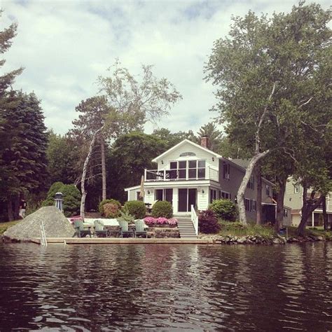 A House Sitting On Top Of A Lake Surrounded By Trees