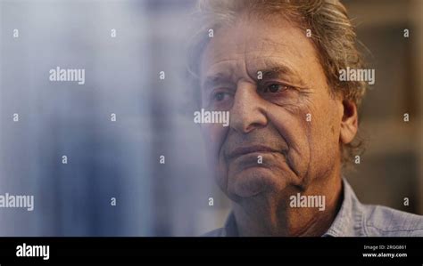 One Serious Contemplative Senior Man Thinking About Life Seen Through Window Reflection