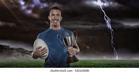 Portrait Smiling Rugby Player Holding Trophy Stock Photo