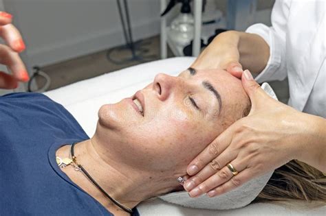 Blonde Lady Receives Facial Cleansing In A Specialized Clinic Massage After Application Of