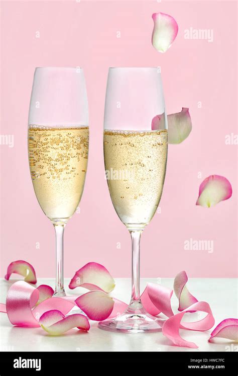 Two Glasses Of Champagne Pink Ribbon And Falling Rose Petals Stock