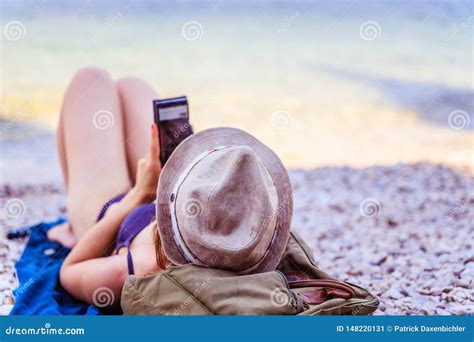 Smartphone Auf Dem Strand Sch Nes Junges M Dchen Mit Strohhut Im Bikini Liegt Auf Dem Pebble