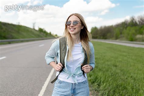 Cheery Young Lady In Casual Summer Clothes Walking Along Road In