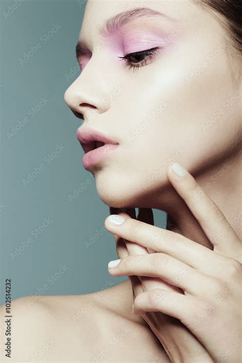 Portrait of a beautiful girl face in profile against a blue background Stock Photo | Adobe Stock